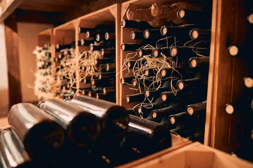 wooden racks with wine bottles in storage room