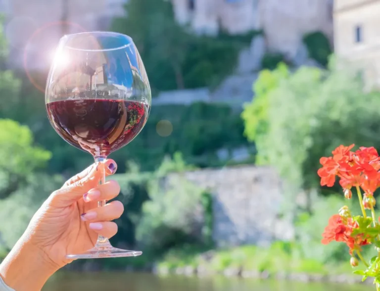 a glass of red wine in a female hand