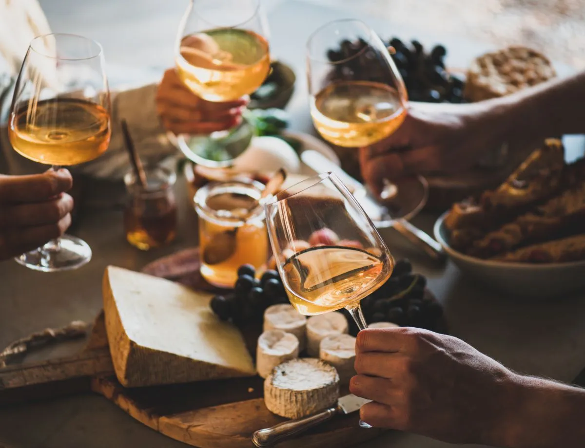 hands of people holding wineglasses with white wine