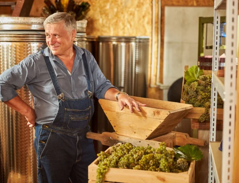 joyful winemaker smiling and posing inside the winery